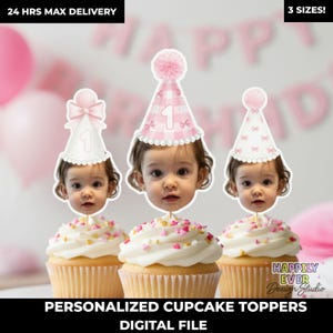 May include: Three cupcakes with white frosting and heart sprinkles, each topped with a personalized image of a baby wearing a pink party hat. The hats have a number 1 and bow or pom-pom details. Text reads "PERSONALIZED CUPCAKE TOPPERS DIGITAL FILE."