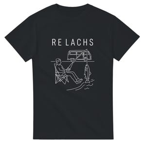 以下が含まれることがあります： 黒いTシャツ。白いイラストは、釣り人、キャンピングカー、そして「RELACHS」という言葉です。イラストは、折りたたみ椅子に座っている釣り人、釣り糸にかかった魚を描いています。キャンピングカーが近くに駐車されています。