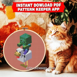 May include: A cross-stitch pattern of a green Minecraft zombie riding a white chicken. The pattern is displayed in a wooden embroidery hoop on a brown and orange surface. The text "INSTANT DOWNLOAD PDF PATTERN KEEPER APP" is displayed in red at the top of the image.
