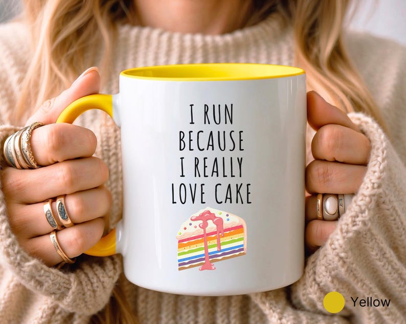May include: White ceramic mug with a yellow rim. The mug has a black text that reads "I run because I really love cake" and a colorful cake illustration.