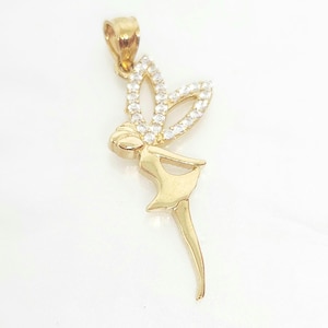 May include: A gold pendant shaped like a fairy with a smooth, polished finish on the body and dress. The fairy features two wings encrusted with small, clear, sparkling white stones and includes a gold bail at the top for attachment to a chain.