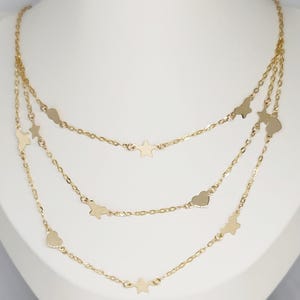 May include: A gold layered necklace with a delicate chain and star and heart charms.