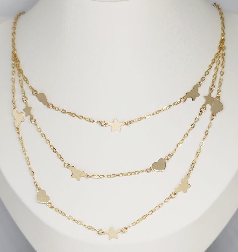 May include: A gold layered necklace with a delicate chain and star and heart charms.