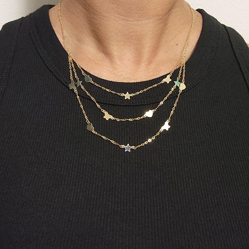 May include: A gold layered necklace with a delicate chain and alternating star and heart charms.