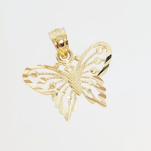 Puede incluir: Un colgante de mariposa de oro con un diseño detallado. El colgante tiene un diseño delicado e intrincado con un acabado texturizado.