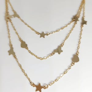 May include: A gold layered necklace with star and heart charms.