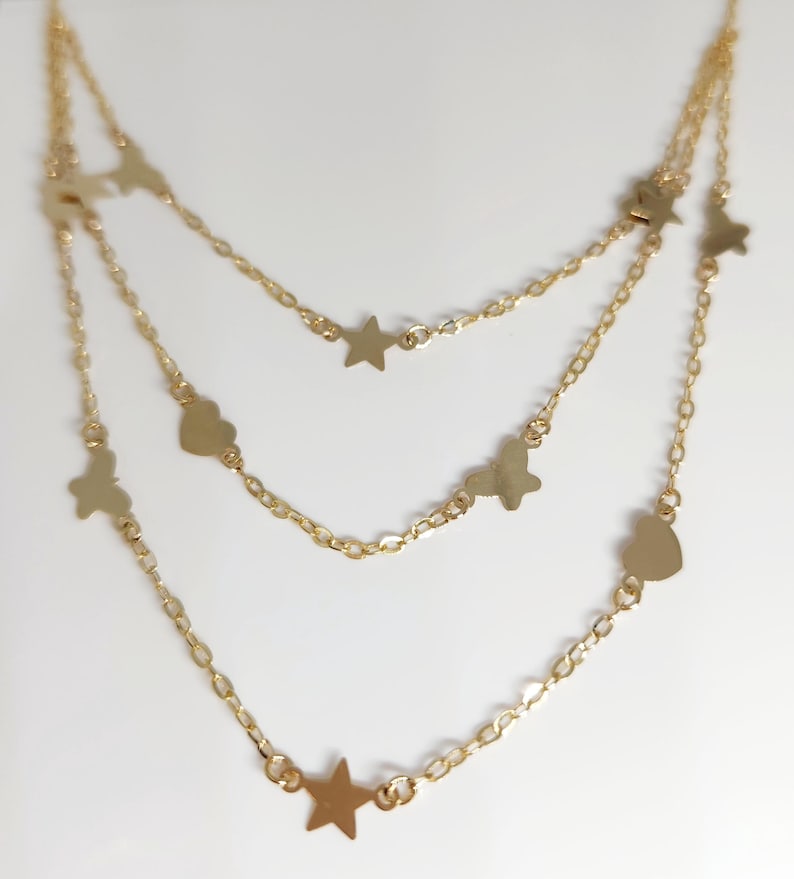May include: A gold layered necklace with star and heart charms.