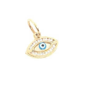 May include: A gold charm in the shape of an eye, featuring a central blue and white pupil surrounded by a gold iris. The outer edge of the eye is encrusted with small, clear, sparkling stones, and a small gold jump ring is attached to the top.