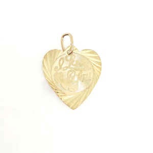 May include: A gold heart-shaped pendant featuring a textured, sunburst-patterned border and a central circular inlay. The centre displays the engraved script text I Love You, accompanied by small heart motifs, and includes a gold jump ring bail.