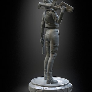 Pode incluir: Uma estatueta monocrom&aacute;tica cinza de um personagem em p&eacute; sobre uma base circular. O personagem veste uma jaqueta, cal&ccedil;as justas e botas, segurando um rifle sobre os ombros e uma pistola na m&atilde;o direita. O texto h3LLcreator &eacute; vis&iacute;vel.