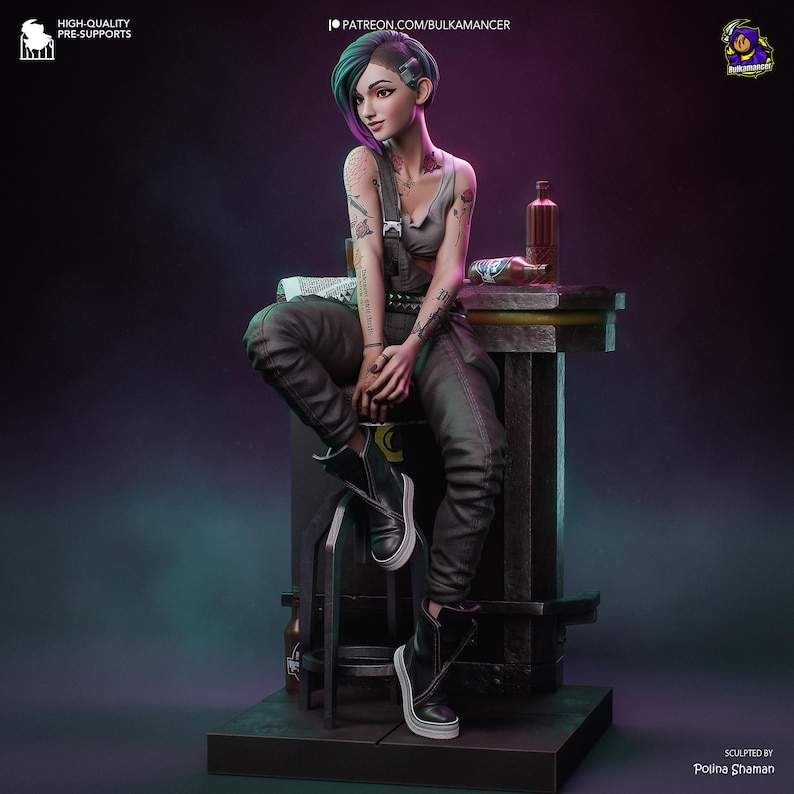 May include: A detailed figurine of a woman with tattoos, wearing a gray tank top, black overalls, and black boots. She is seated on a stool next to a small table with a bottle and a newspaper. The figurine has green and purple hair.