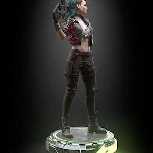 Pode incluir: Uma estatueta de um personagem com moicano verde-azulado, vestindo uma jaqueta vermelha curta, um top branco e cal&ccedil;as t&aacute;ticas pretas com botas. O personagem segura um rifle escuro e est&aacute; sobre uma base circular iluminada em verde com texto.