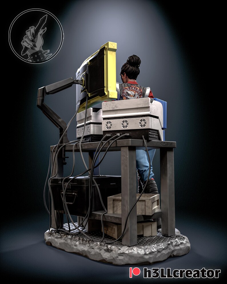 May include: A detailed figurine of a person seated at a computer workstation. The figure is wearing a jacket with text on the back. The workstation includes a monitor with a yellow frame, multiple computer components, and a network of cables. The base is a textured, gray surface.