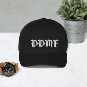 May include: Black and white embroidered baseball cap with the text "DDMF" in a gothic font.
