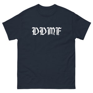 May include: A navy blue t-shirt with the word "DDMF" printed in white in a gothic font.