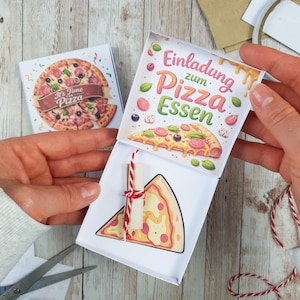Puede incluir: Una caja de invitación blanca con temática de pizza con una ilustración de una porción de pizza y un pergamino enrollado atado con hilo rojo y blanco. La caja presenta un gráfico de pizza y el texto "It's Time Pizza". La caja abierta muestra el texto "Einladung zum Pizza Essen".