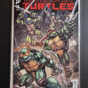 May include: Comic book cover featuring the Teenage Mutant Ninja Turtles. The illustration shows the four turtles in action, wielding weapons. The cover has the title "Teenage Mutant Ninja Turtles" and the number 13.