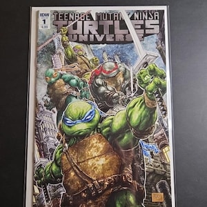 May include: Teenage Mutant Ninja Turtles Universe comic book cover. The cover features the four turtles in action, with Leonardo in the foreground. The comic is in a protective sleeve.