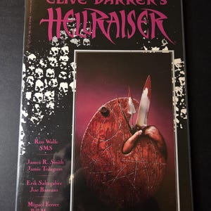 Könnte beinhalten: Comic-Cover für Clive Barkers Hellraiser. Der Titel ist pinkfarben auf schwarzem Hintergrund. Das Cover-Artwork zeigt ein rotbraunes, eiförmiges Objekt mit Messern und einer Hand. Das Cover listet auch die Namen der Künstler auf.