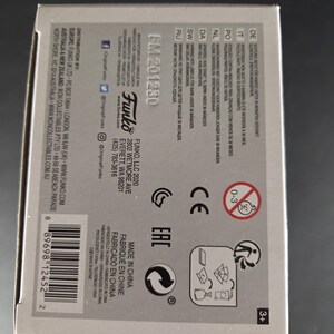 Pu&ograve; includere: Una scatola di prodotti Funko con il testo "FM 201230" e varie avvertenze di sicurezza. La scatola include il logo Funko, un codice a barre e il testo "Made in China". La scatola &egrave; grigia e bianca.