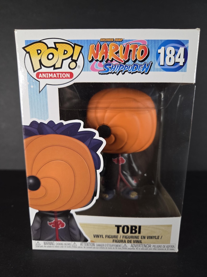 Pu&ograve; includere: Una figura Funko Pop! Animation di Tobi da Naruto Shippuden, numero 184. La figura &egrave; in una scatola con il logo Pop! Animation e il logo Naruto Shippuden. La figura &egrave; arancione e nera.