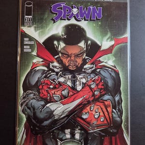 May include: Spawn comic book issue 311, featuring a portrait of Chadwick Boseman. The cover art showcases Spawn in a black and red costume, with the text "IN MEMORY OF CHADWICK BOSEMAN (1976-2020)" at the top. The comic is in a protective sleeve.