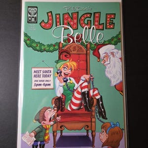 May include: A comic book cover titled "Jingle Belle" featuring a cartoon woman in a green outfit and striped stockings, seated on a throne. Santa Claus is in the background. Text includes "Meet Santa Here Today 3pm-4pm".