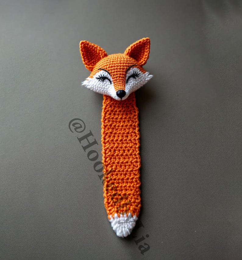 May include: Orange and white crocheted fox bookmark with a cute face.