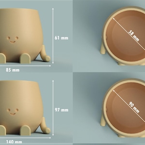 K&ouml;nnte beinhalten: Zwei beige Keramik-Pflanzgef&auml;&szlig;e, eines klein und eines gro&szlig;, jeweils mit einem l&auml;chelnden Gesicht und kleinen Armen und Beinen. Der kleine Pflanztopf ist 85 mm breit, 61 mm hoch und hat einen Durchmesser von 58 mm. Der gro&szlig;e Pflanztopf ist 140 mm breit, 97 mm hoch und hat einen Durchmesser von 90 mm.