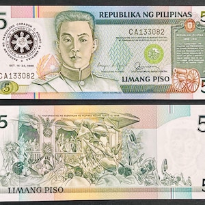 May include: Two Philippine 5 Piso banknotes. The front of the bill features a portrait of a man and text in Filipino. The back of the bill depicts a historical scene with text in Filipino. The bills are in shades of green, pink, and blue.