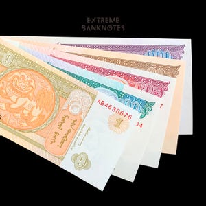 May include: A collection of colorful banknotes fanned out against a black background. The bills display various designs and colors, including orange, green, and purple. The text "EXTREME BANKNOTES" is at the top.
