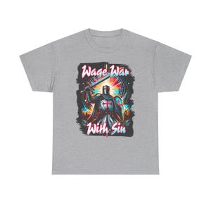 May include: A heather gray t-shirt featuring a graphic of a knight in armor holding a sword and shield. The knight wears a white tunic with a red cross. The text "Wage War With Sin" appears in stylized lettering above and below the central figure.