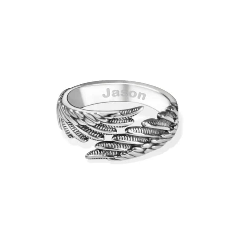 May include: Silver ring with a design of two angel wings. The ring is engraved with the name "Jason".