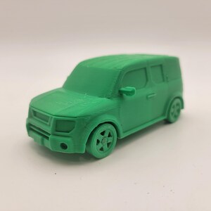 Puede incluir: Un coche de juguete verde modelo de un Honda Element, un SUV compacto con un diseño cuadrado. El coche tiene ruedas negras y una parrilla delantera detallada.