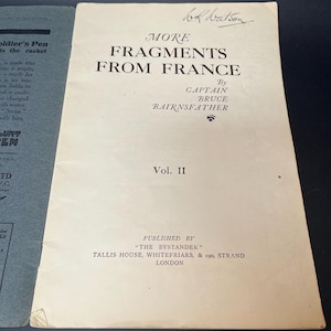 K&ouml;nnte beinhalten: Ein Vintage-Buchcover mit dem Titel "MORE FRAGMENTS FROM FRANCE" von Captain Bruce Bairnsfather. Das Cover ist cremefarben mit schwarzem Text und einer handschriftlichen Signatur. Das Buch ist Band II, herausgegeben von "The Bystander" in London.