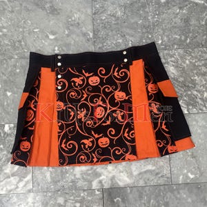 May include: A black and orange kilt with a Halloween-themed print of pumpkins and bats. The kilt has a black waistband with silver buttons and two orange pockets on the sides.
