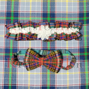 May include: A red, blue, green, and yellow plaid bow tie and garter set. The garter has a white lace flower accent.