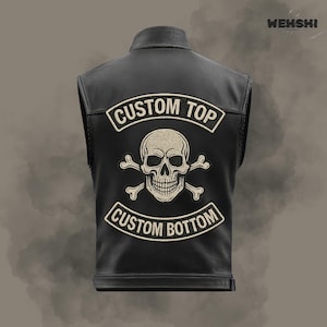 Könnte beinhalten: Schwarze Lederweste mit einem Totenkopf- und gekreuzten Knochen-Patch. Auf der Weste sind die Worte "CUSTOM TOP" und "CUSTOM BOTTOM" gestickt. Die Weste ist ärmellos und hat einen Kragen.