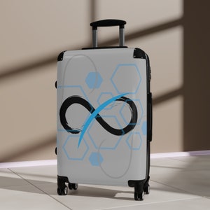 May include: White suitcase with a black infinity symbol and blue geometric patterns. The suitcase has black wheels and a black handle.