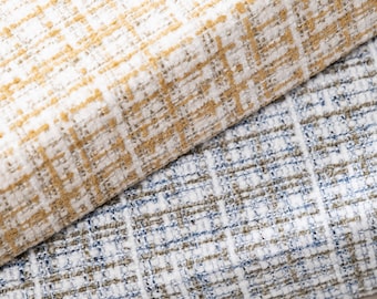 May include: Two pieces of fabric with a woven texture. The top piece is a light yellow and white fabric with a checkered pattern. The bottom piece is a light blue and white fabric with a checkered pattern.
