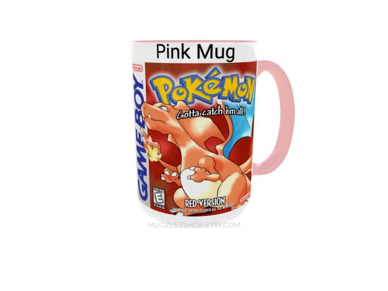 May include: A pink ceramic mug featuring the Pok&eacute;mon Red Version Game Boy game cover art. The design includes the orange Charizard character, the Pok&eacute;mon logo, the text Gotta catch 'em all!, Red Version, and the Game Boy and E rating logos.