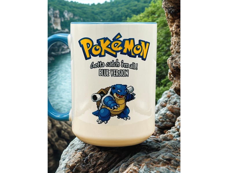 May include: A white ceramic mug with a blue handle and interior rim. The front features the yellow and blue Pok&eacute;mon logo, the text Gotta catch 'em all! BLUE VERSION, and a pixelated graphic of the blue turtle-like creature Blastoise.