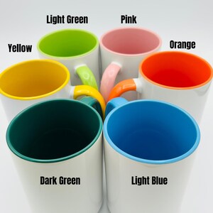 May include: A collection of white ceramic mugs with colorful interiors and handles. The interior colors include yellow, light green, pink, orange, dark green, and light blue. The handles match the interior colors. Text on the image indicates the colors.
