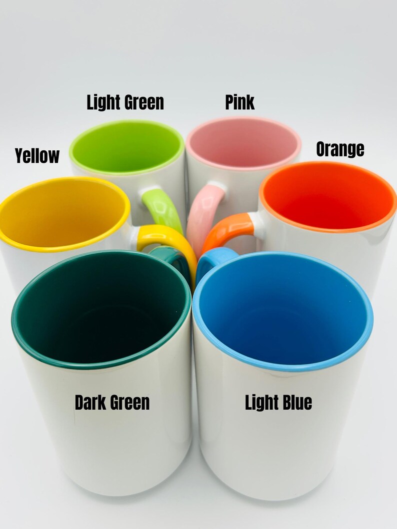 May include: A collection of white ceramic mugs with colorful interiors and handles. The interior colors include yellow, light green, pink, orange, dark green, and light blue. The handles match the interior colors. Text on the image indicates the colors.