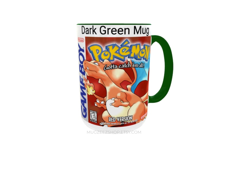 May include: A dark green ceramic mug featuring a graphic print of the Pok&eacute;mon Red Version Game Boy game cover. The design includes the orange Charizard character, the Pok&eacute;mon logo, the text Gotta catch 'em all!, and the Game Boy branding.