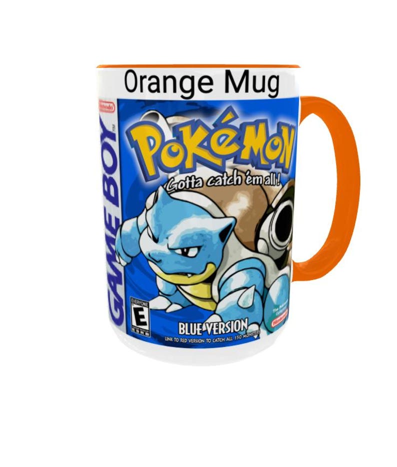 May include: A white ceramic mug with an orange handle and rim, featuring a graphic of the Pok&eacute;mon Blue Version Game Boy game cover. The design includes the Pok&eacute;mon logo, the text Gotta catch 'em all!, Blue Version, and Game Boy branding.