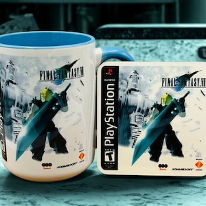 Op de afbeelding: Witte keramische mok en onderzetter set met Final Fantasy VII artwork. De mok heeft een blauwe binnenkant en oor, de onderzetter toont het PlayStation logo en speld details. Het ontwerp toont een personage met een groot zwaard.