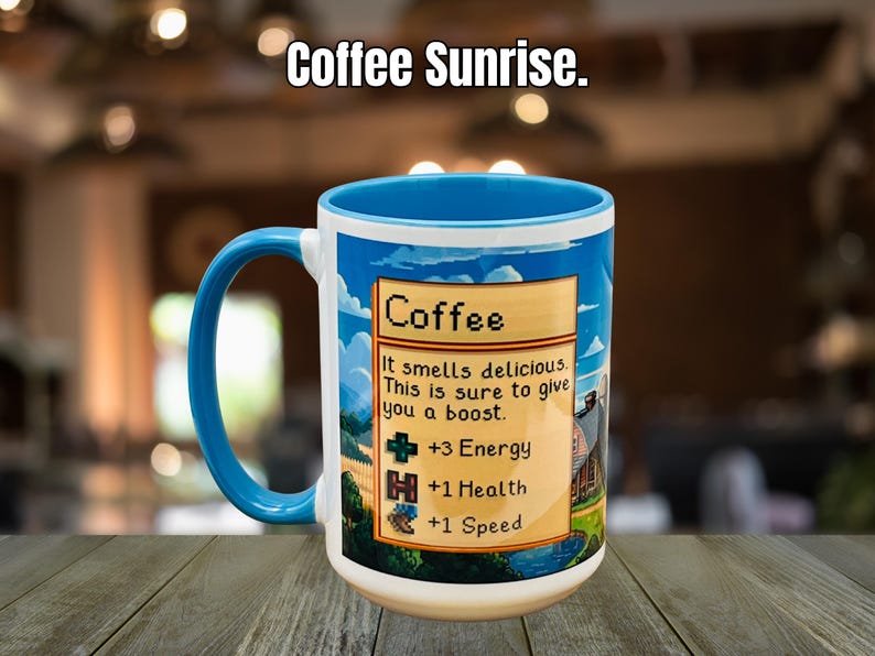 May include: A white ceramic mug with a blue handle and rim, featuring the text "Coffee Sunrise." The mug has a colorful design with the word "Coffee" and text that reads "It smells delicious. This is sure to give you a boost." The design also includes +3 Energy, +1 Health, and +1 Speed.