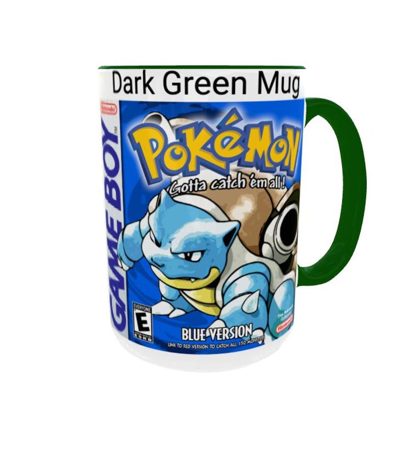 May include: A dark green mug featuring a graphic print of the Pok&eacute;mon Blue Version Game Boy game cover. The design includes the Pok&eacute;mon logo, the text Gotta catch 'em all!, the character Blastoise, and the ESRB E rating symbol on a blue background.
