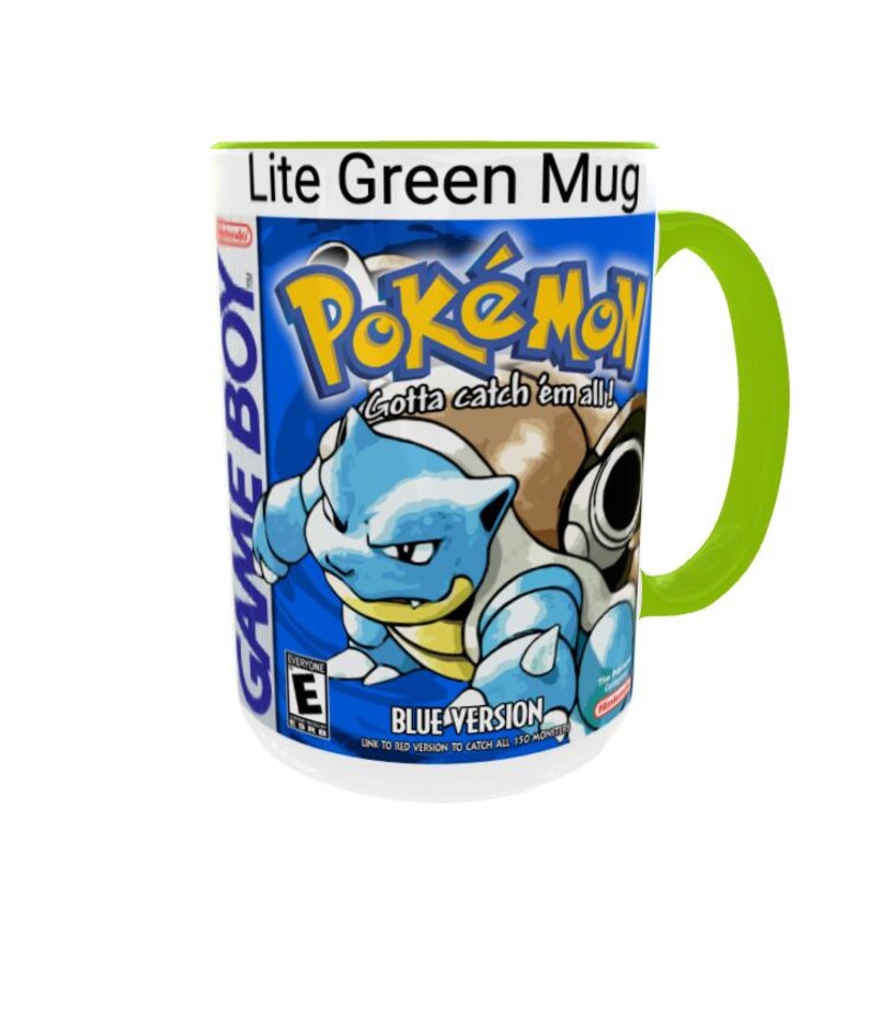 May include: A white ceramic mug with a bright lime green handle and interior rim. The exterior features a graphic print of the Pok&eacute;mon Blue Version Game Boy game box art, including the Blastoise character, the Pok&eacute;mon logo, and text.